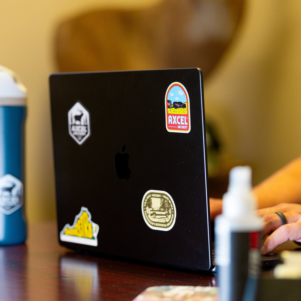Several T.R.U. Ball and Axcel stickers applied to a laptop