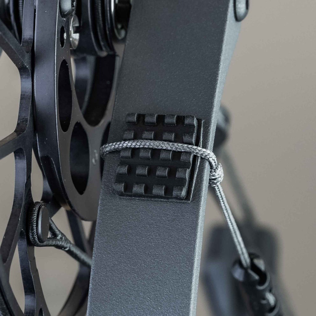 Knobby limb pad mounted on a bow limb with the rest actuation cord tied off