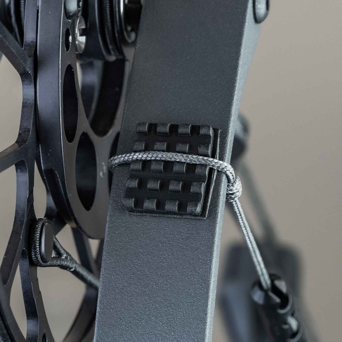 Knobby limb pad mounted on a bow limb with the rest actuation cord tied off