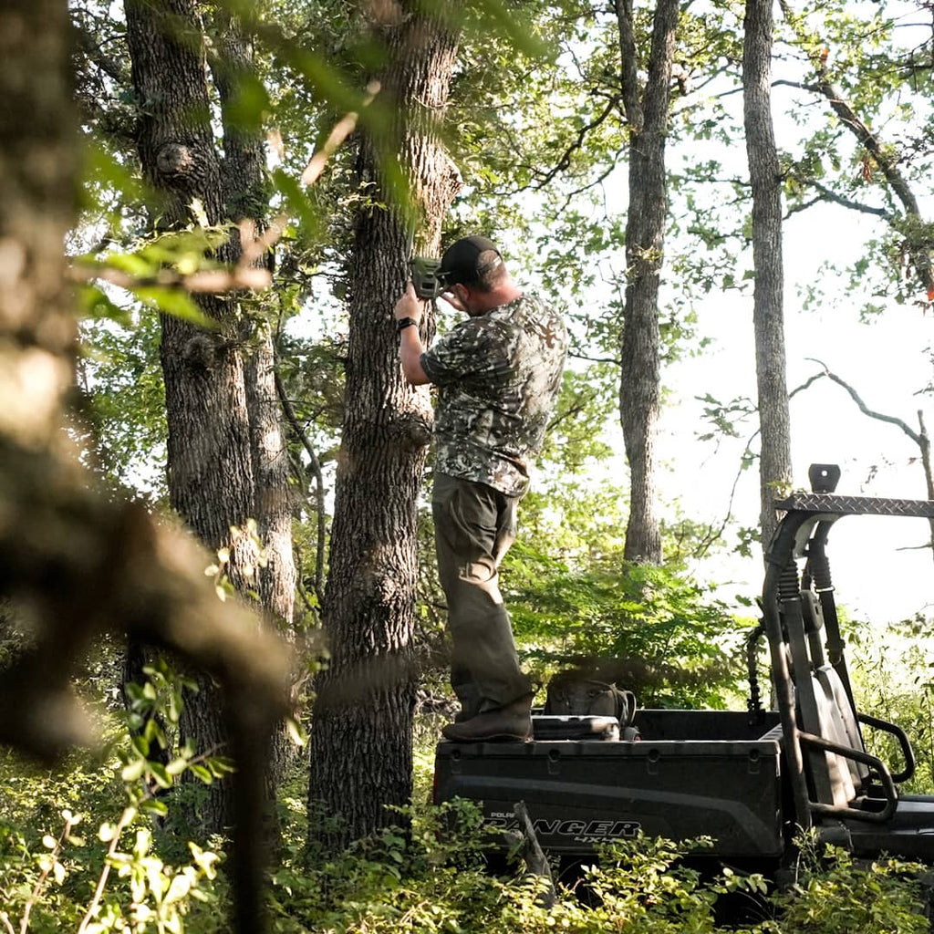 SKRE Venture Flex Pant worn hanging a trail camera