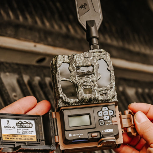 Browning Defender Pro Scout Max HD trail camera, open in the field, showing the control panel