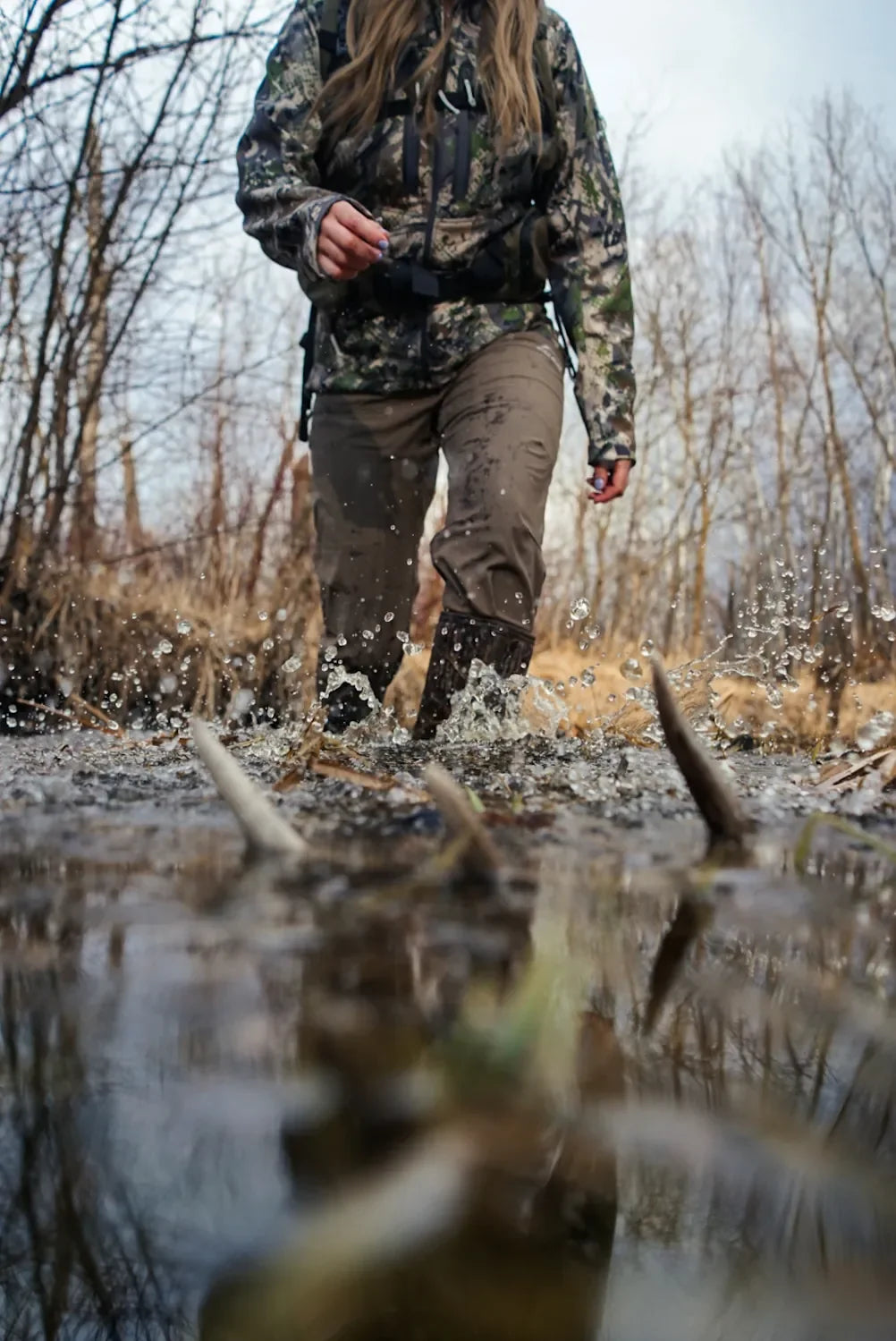 SKRE Venture Flex Pant crossing water, showing DWR finish