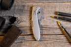 Browning Stainless Scalpel on a weathered wood bench with blade dispenser