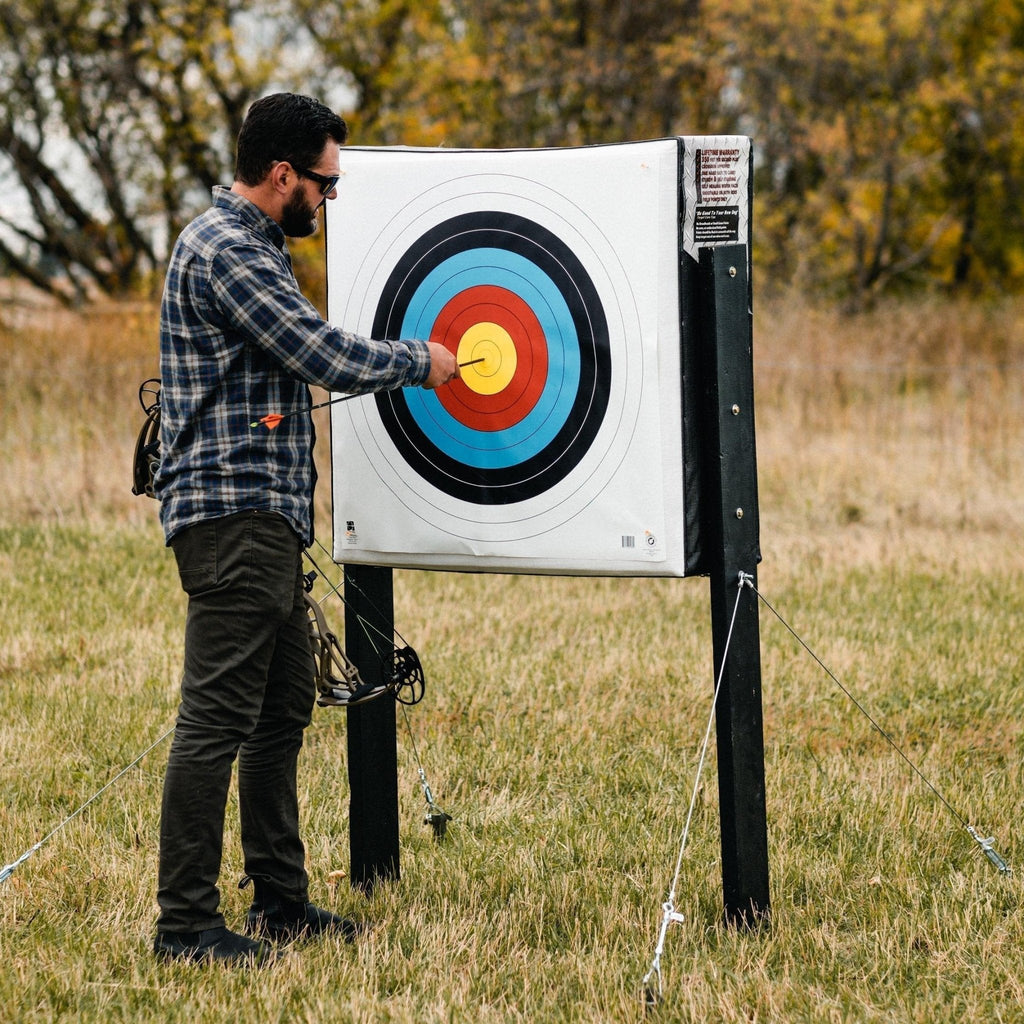 Archer pinning a paper face to the RangeDog PLUS on its outdoor stand